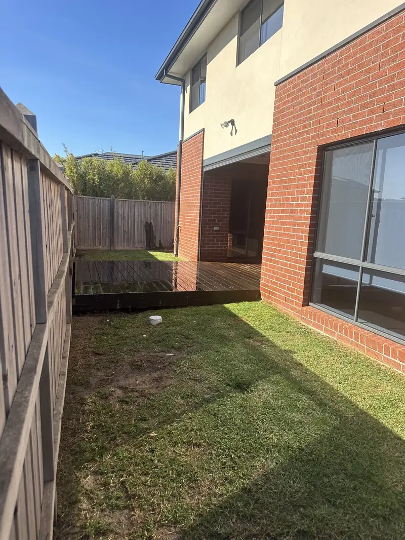 Brick home frontage with grass strip and timber decking, tidied by C&J