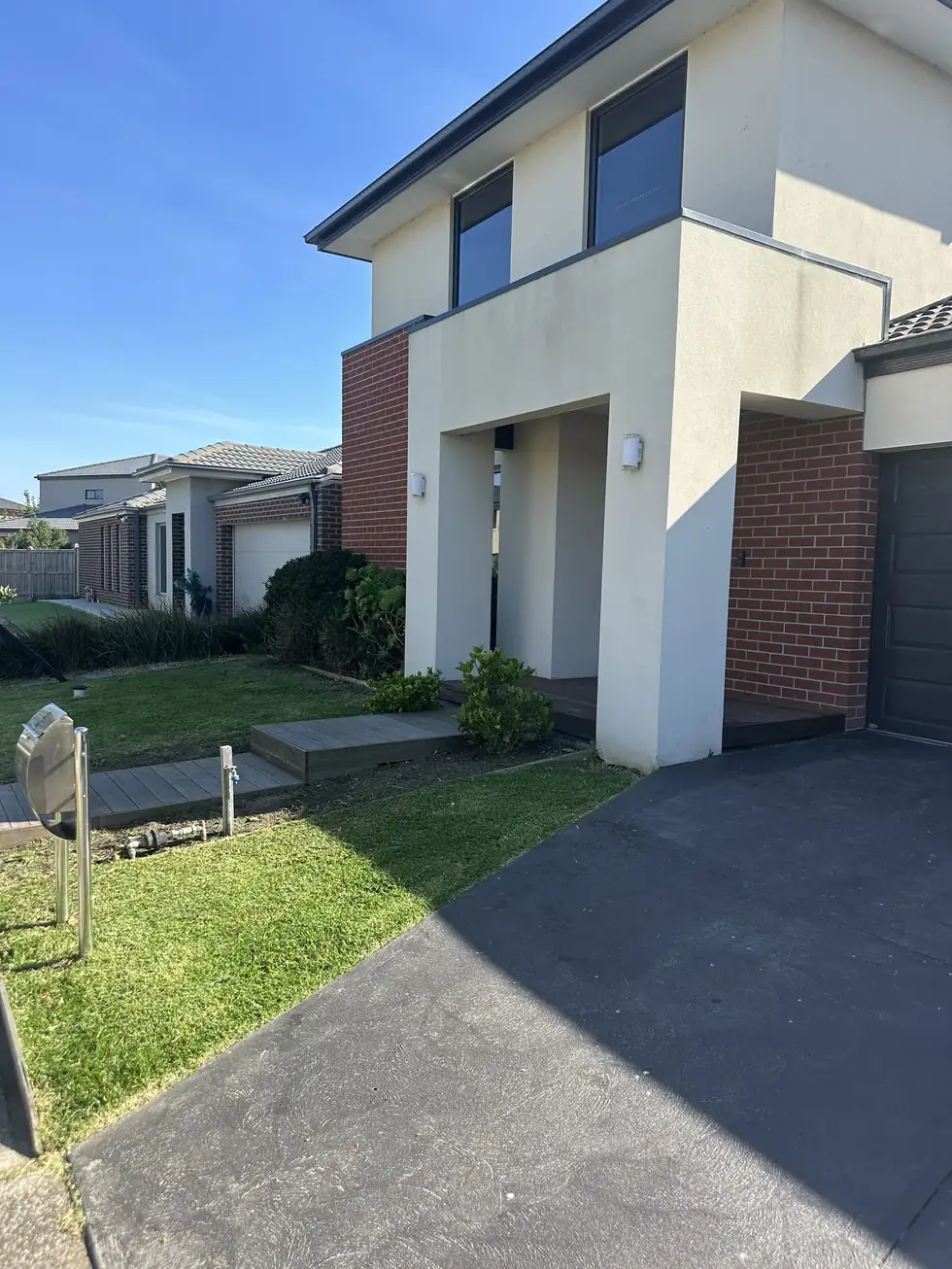 Double-storey brick home frontage and lawn maintained by C&J