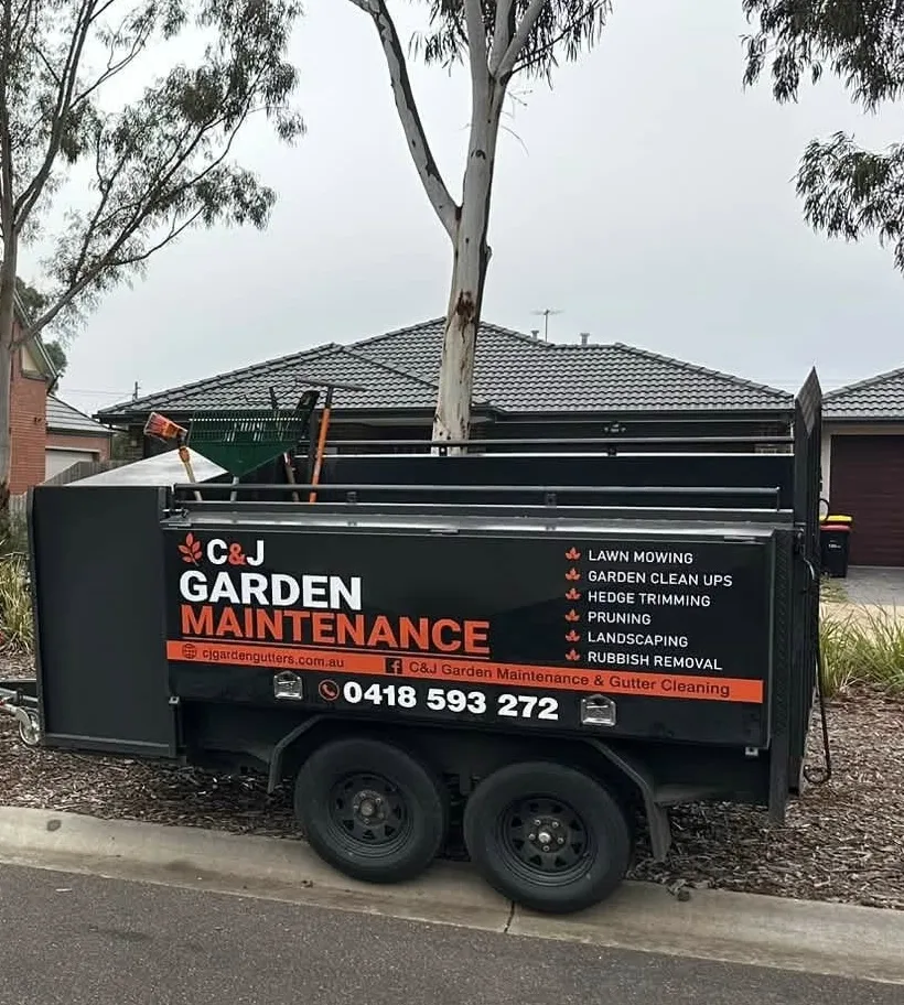The C&J Garden Maintenance trailer, signwritten with the service list and Craig's number, on site